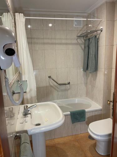 a bathroom with a sink and a tub and a toilet at Apartamentos Colón2 in Playa de las Americas