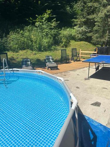 a blue swimming pool with a table and chairs at Hotel Dykyi Med in Tatariv