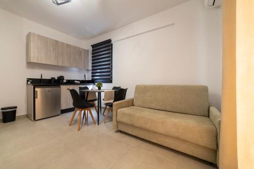 a living room with a couch and a table with chairs at NS Apartments Nydri in Nydri