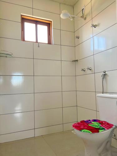a bathroom with a toilet and a window at Pousada Paraíso in Lavras Novas