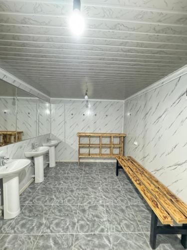 a bathroom with two sinks and a wooden bench at Altygat Lodge Barskoon in Barskoon