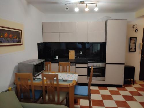 a kitchen with a dining table and a refrigerator at Una apartmani Petrovac in Petrovac na Moru