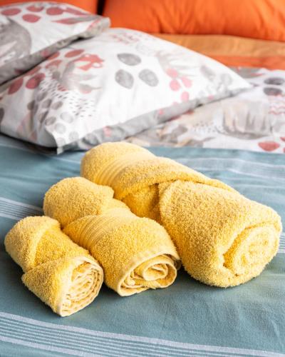 a pile of burritos sitting on top of a bed at Ciriga Sicily Glamping in Santa Maria Del Focallo