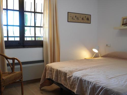 a bedroom with a bed and a chair and a window at Casa a Solric con piscina compartida, 3 habitaciones, cerca de L'Estartit y playas - ES-323-40 in L'Estartit