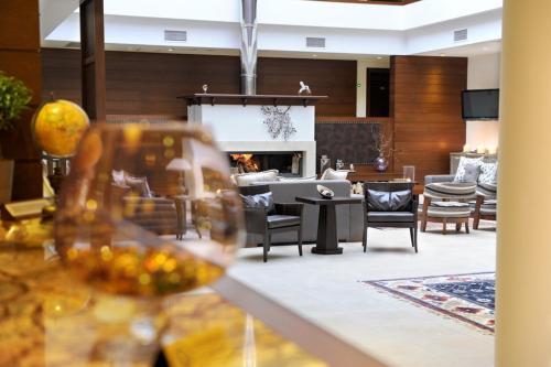 a living room with a fireplace and a wine glass at Agapi Luxury Hotel in Kato Loutraki