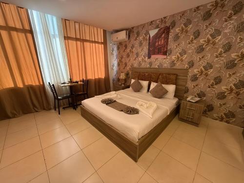a bedroom with a bed and a table in it at El RAYYAN HOTEL SUITES in Amman