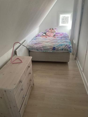a small bedroom with a bed and a dresser at Villa med pool i närheten av Örebro in Hällefors