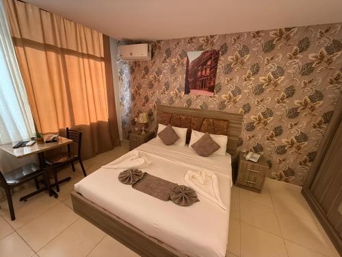 a bedroom with a bed with white sheets and bows at El RAYYAN HOTEL SUITES in Amman