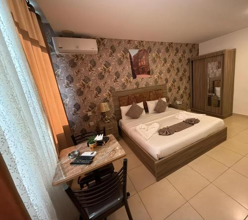 a hotel room with a bed and a desk with a table sidx sidx at El RAYYAN HOTEL SUITES in Amman
