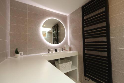 une salle de bain avec un lavabo et un miroir dans l'établissement Lenoir magnifique maison 8 pers avec terrasse, à Reims