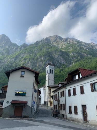 a village with a clock tower and a mountain at Rustichello in Timau