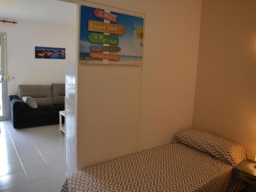 - une chambre avec un lit et une affiche murale dans l'établissement Apartamento acogedor en la playa con acceso directo al mar y piscina en L'Estartit - ES-323-22, à L'Estartit