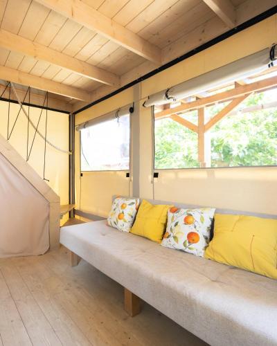 a bench in a room with two pillows on it at Ciriga Sicily Glamping in Santa Maria Del Focallo