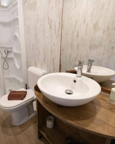 a bathroom with a white sink and a toilet at Ciriga Sicily Glamping in Santa Maria Del Focallo