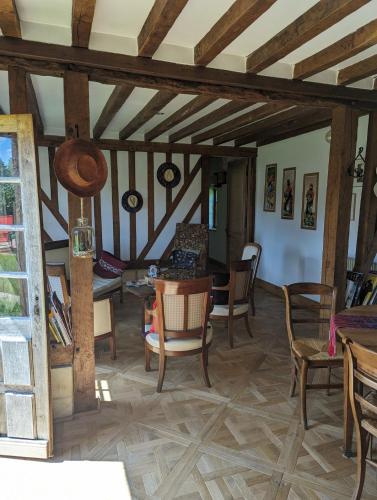 - un salon avec des plafonds en bois, une table et des chaises dans l'établissement Normandy house with tennis, à Bonneville-la-Louvet