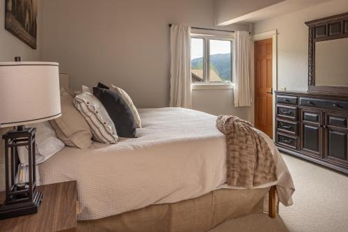 a bedroom with a bed with a dresser and a window at Crail Creek 85 in Big Sky