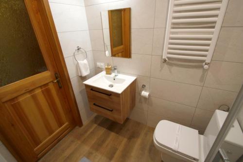 a bathroom with a white sink and a toilet at Willa 1910 in Karpacz