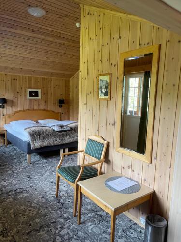 a bedroom with a bed and a table and a chair at Toftemo Turiststasjon in Dovre