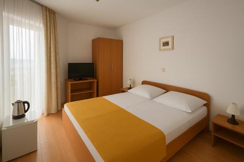 una camera da letto con un letto grande e una televisione di Villa Toni a Sveti Filip i Jakov (Santi Filippo e Giacomo)