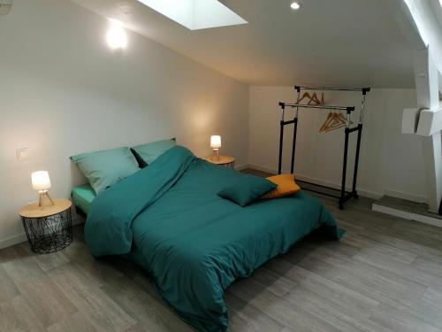 - une chambre avec un grand lit vert et 2 lampes dans l'établissement L'appartement du Jardin Perdoux, à Bergerac