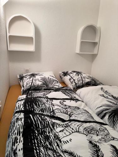 une chambre avec un lit avec une couette noire et blanche dans l'établissement Studio with terrace in the center with AC, à Antibes