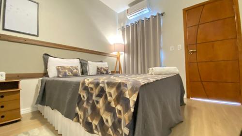 a bedroom with a bed with a dresser and a cabinet at Hotel Capital da Fe in Aparecida