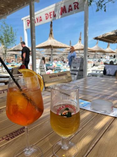 two glasses of beer sitting on top of a wooden table at Roca Del Mar in Mamaia Nord