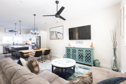 a living room with a couch and a table at New Build with Rooftop Deck & Panoramic Ocean Views in Kill Devil Hills