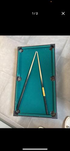 un étui vert avec deux battes de baseball à l'intérieur dans l'établissement Séjour insolite sur une île, à Ézy-sur-Eure