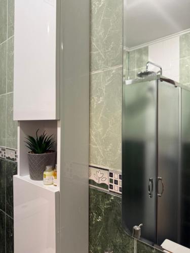 a bathroom with a shower with a stainless steel refrigerator at Sea Garden Escape - Byala in Byala