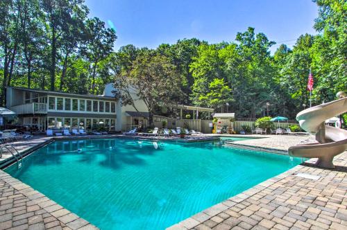 a swimming pool with blue water in front of a house at Hot Tub and Pet-Friendly! Gatlinburg Resort Cabin in Gatlinburg