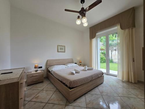 Un dormitorio con una cama y un ventilador de techo. en Belvedere - By Ligooria, en Pietra Ligure