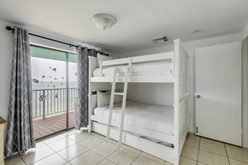 a bedroom with bunk beds and a balcony at Walk to Beach Florida Keys Gem with Ocean Views in Layton