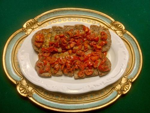 a plate of food with tomatoes on toast at Dimora Umbra al civico 65 in Campello sul Clitunno