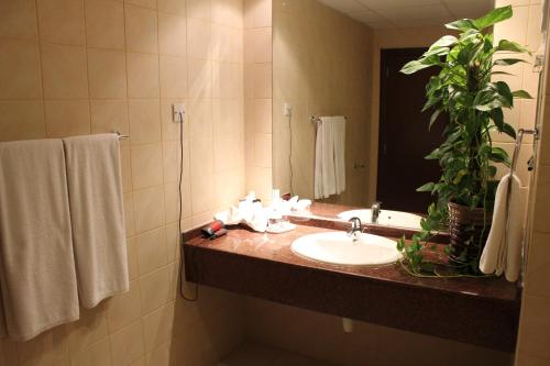 a bathroom with a sink and a mirror at Reem Hotel Apartments in Al Khuwayrīyah