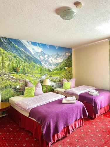 two beds in a room with a painting on the wall at Parkhotel Sonne in Schönau im Schwarzwald
