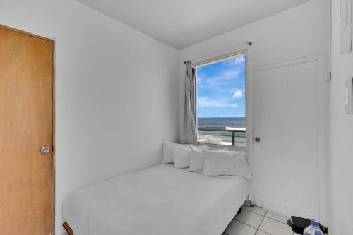 a bedroom with a bed and a window with the ocean at Bella Surf Inn in Isabela