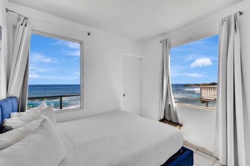 a bedroom with a bed and a view of the ocean at Bella Surf Inn in Isabela