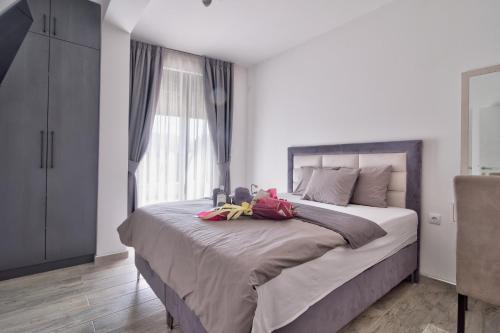 a bedroom with a large bed with stuffed animals on it at Vision apartmani Vrnjačka Banja in Vrnjačka Banja