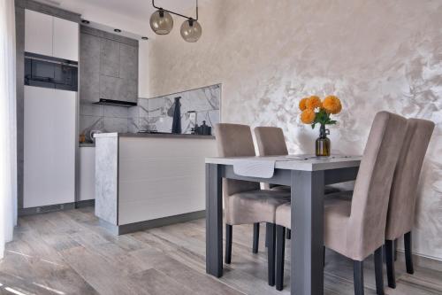 a kitchen and dining room with a table and chairs at Vision apartmani Vrnjačka Banja in Vrnjačka Banja