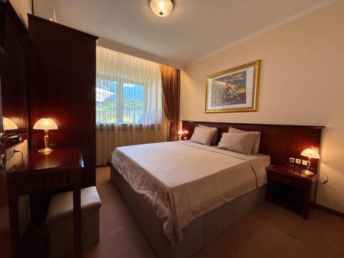a hotel room with a bed and a window at Downtown Bansko Luxury Resort in Bansko