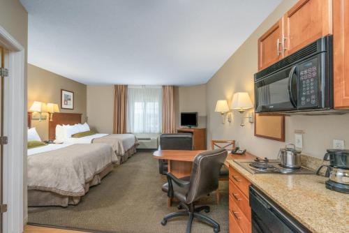 a hotel room with two beds and a desk at Candlewood Suites New Bern by IHG in New Bern