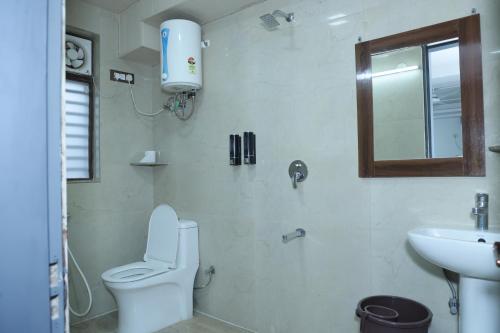 ein weißes Badezimmer mit Toilette und Waschbecken in der Unterkunft Raj Residency Gurgaon in Gurgaon