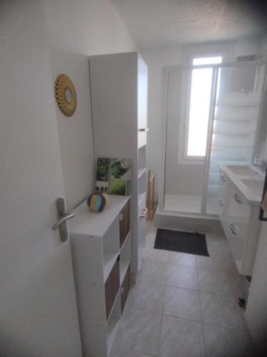 une cuisine blanche avec un évier et une fenêtre dans l'établissement Au calme, proche de Perpignan et des plages, à Perpignan