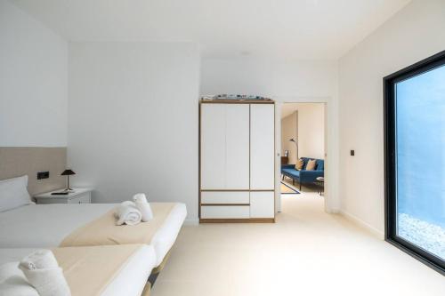 a white room with a bed and a large window at Apt new Mestalla | jacuzzi | billar | ping pong in Valencia