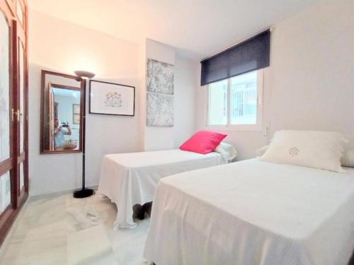 a white room with two beds and a mirror at Habitación Silvia Marbella in Marbella