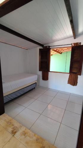 a small room with a bed and a window at Pousada Preguiça in Canoa Quebrada