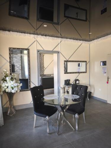 une salle à manger avec une table et des chaises en verre dans l'établissement Suite Hollywood by les spa de venus, à Charavines