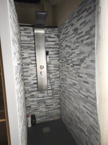La salle de bains est pourvue d'une douche et d'un mur en briques. dans l'établissement Suite Hollywood by les spa de venus, à Charavines
