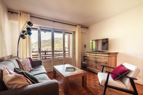 un salon avec un canapé et une télévision dans l'établissement Le Central - In the heart of Megève, à Megève